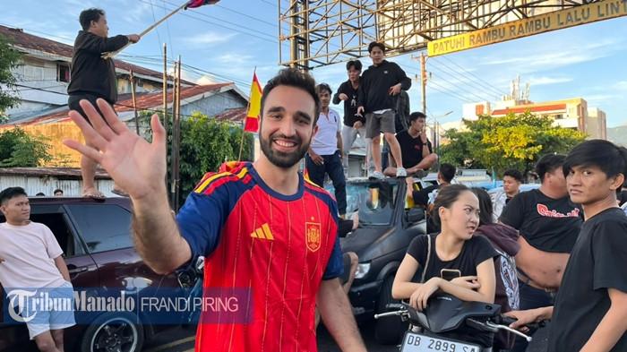 TURIS SPANYOL - Dua wisatawan asal Spanyol, Javi Roldan dan teman perempuannya ikut merayakan kemenangan El Matador pada final Piala Dunia 2026 di Kota Manado, Sulawesi Utara, Senin, 20 Juli 2026. Javi dan pasangan tampak naik di bagian atap mobil dan mengibar-ngibarkan bendera Spanyol bersama sekelompok pendukung lokal saat konvoi kemenangan skuad Spantol di Manado.