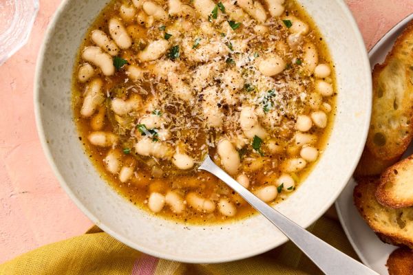 A recipe image is Brothy Cacio e Pepe Beans Credit: Photographer Victor Protasio, Food Stylist Emily Nabors Hall, Prop Stylist Phoebe Hauser.