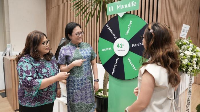 Novita Rumngangun, Wakil Presiden Direktur & Deputy CEO Manulife Indonesia (kiri) dan Caroline Utomo, Chief Operating Officer Manulife Indonesia (Tengah), berinteraksi dengan nasabah dalam kegiatan perayaan HUT ke-41 Manulife Indonesia di Jakarta, Senin (20/7/2026). WARTA KOTA/ANGGA BHAGYA NUGRAHA