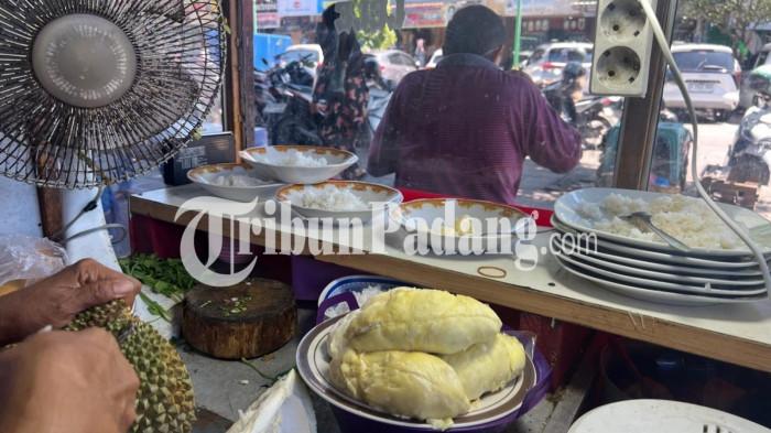 PEDAGANG KETAN DURIAN- Seorang pedagang membuka buah durian menggunakan pisau di Warung Kenzy, Pasar Raya Padang, Sumatera Barat, Selasa (21/7/2026).