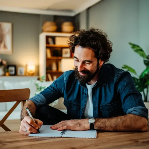 overwhelmed man writing in a journal to expel his chaotic thoughts