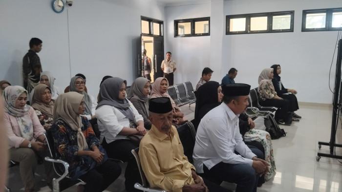 Muksin Badar memakai kameja putih dan peci nasional