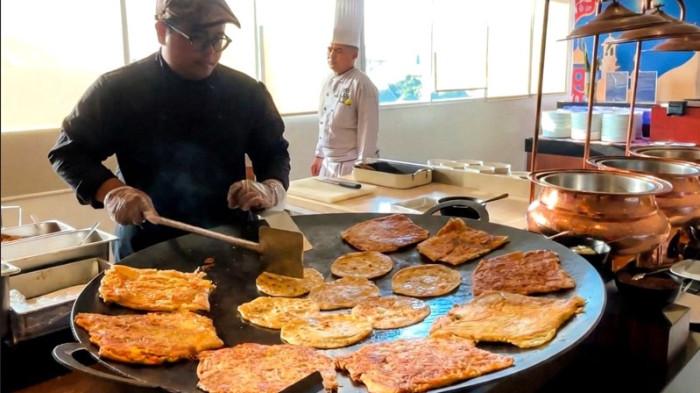 MENU BERBUKA - Chef menyiapkan martabak Mesir dan prata di live cooking stall saat Food Festival Ramadhan Buffet di Benteng Restaurant, Hotel Santika Premiere Dyandra Medan. Sajian ini menjadi salah satu menu favorit tamu saat berbuka puasa dengan konsep festival kuliner Ramadan.