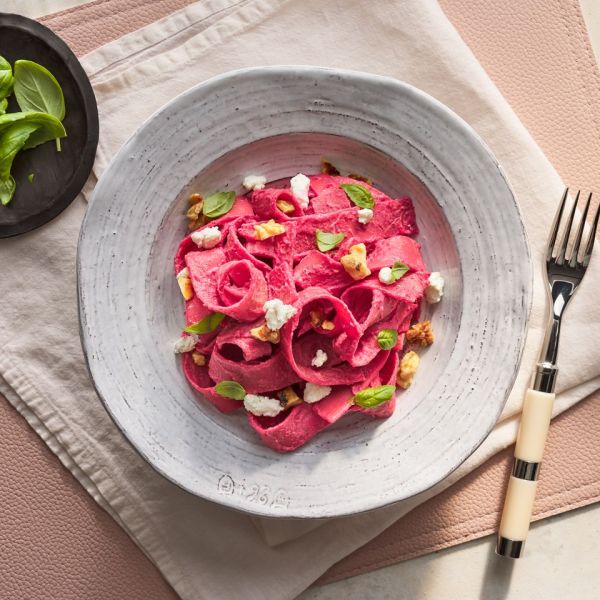 a recipe photo of the Beet Pasta with Goat Cheese and Walnuts served on a plate Credit: Photographer: Fred Hardy, Food Stylist: Julia Levy, Prop Stylist: Josh Hoggle