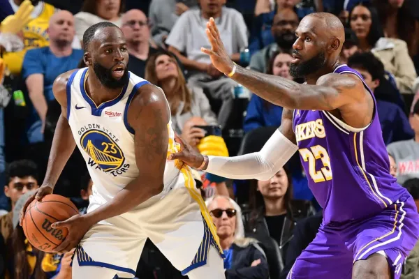 Basketball players Draymond Green and LeBron James facing each other on the court.