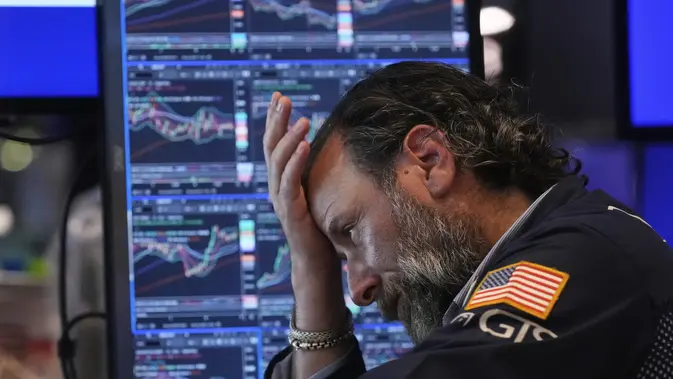 Ilustrasi seorang pedagang efek tengah bekerja di lantai Bursa Efek New York atau Wall Street. (Foto: AP/Richard Drew)