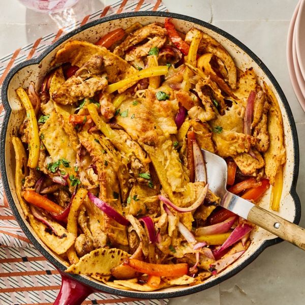 A skillet containing chicken fajita casserole with cooked vegetables and melted cheese served with a spatula Credit: Photographer: Greg DuPree Food Stylist: Salley Mckay Prop Stylist: Prissy Montiel