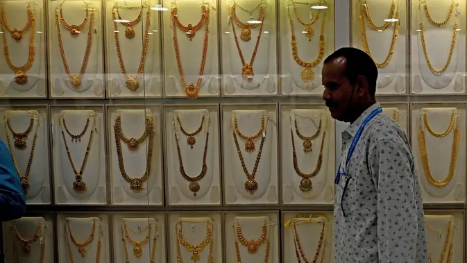 Seorang penjual berjalan melewati kalung emas yang dipajang selama festival Hindu 'Akshaya Tritiya', hari keberuntungan dalam kalender Hindu untuk membeli barang-barang berharga, di ruang pamer perhiasan di Chennai, India. Membeli emas adalah kegiatan yang populer di Akshaya Tritiya, karena ini adalah simbol utama kekayaan dan kemakmuran. (Arun SANKAR / AFP)