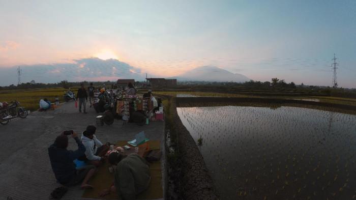 SUASANA SENJA - Pemandangan senja di area jalan yang menghubungkan Morotanjek dan Ngatik di Kecamatan Singosari, Kabupaten Malang, Minggu (26/7/2026). Banyak kaum muda datang ke sini untuk menikmati matahari terbenam di penghujung sore.