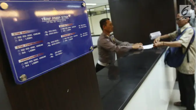 Petugas melayani warga saat mengurus pembayaran pajak kendaraan di Ditlantas Polda Metro Jaya, Jakarta, Senin (31/7). Menyambut Hari Kemerdekaan ke-72 RI, Samsat DKI Jakarta melakukan pemutihan denda pajak. (Liputan6.com/Immanuel Antonius)