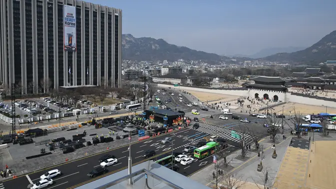 Foto yang diambil pada 16 Maret 2026 menunjukkan para pekerja sedang menyiapkan panggung (C, bawah) untuk konser comeback grup K-pop BTS di depan Gerbang Gwanghwamun (R), gerbang utama Istana Gyeongbokgung, di Seoul. (dok. Jung Yeon-je / AFP)