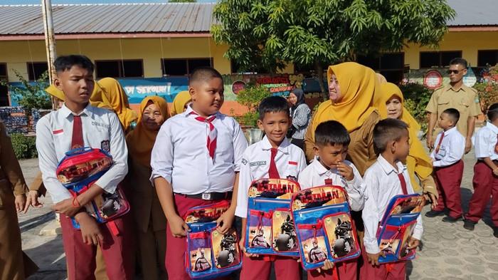 BANTUAN SEKOLAH - Bupati Belitung Timur, Kamarudin Muten saat menyerahkan bantuan pada pekan pertama masuk sekolah di Kecamatan Manggar, awal Juli lalu. Setelah bantuan pribadi dari bupati, Pemkab Beltim siap menyalurkan paket bantuan perlengkapan sekolah gratis yang lebih lengkap berupa seragam, sepatu, tas, hingga atribut dari APBD pada Agustus 2026 mendatang.
