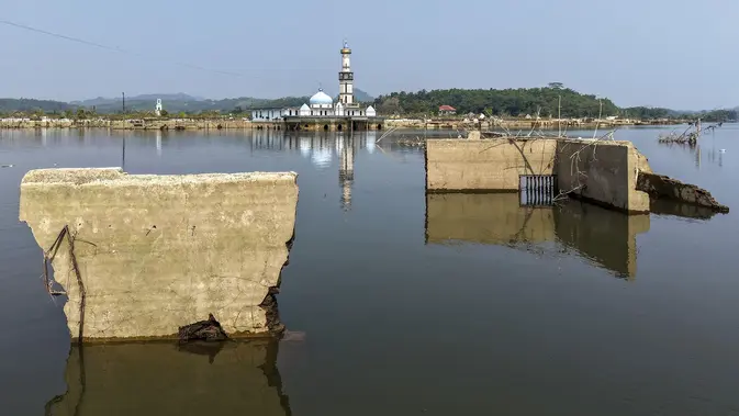 Bangunan mesijd dan puing-puing bangunan rumah yang kembali muncul di kawasan Bendungan Karian yang mengering di Kampung Somang, Lebak, Banten, Kamis (30/7/2026). (AFP/ Bay Ismoyo)