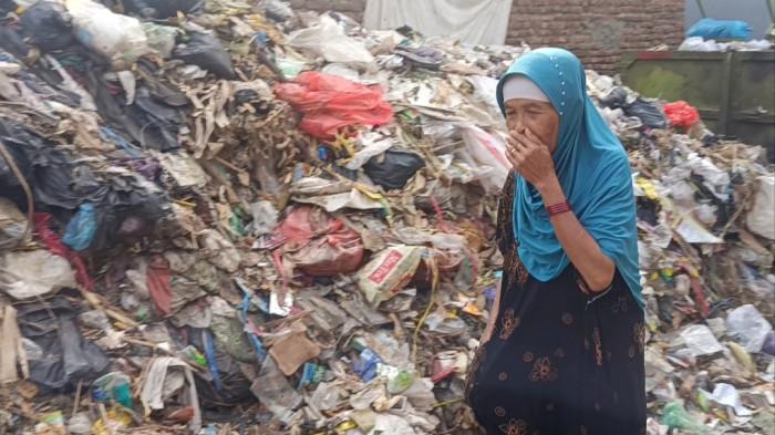 SAMPAH MENUMPUK - Selama sekitar empat bulan terakhir, gunungan sampah setinggi hampir dua meter menutup sebagian akses jalan di Gang Bahagia, Desa Karangmulya, Kecamatan Plumbon, Kabupaten Cirebon, Jawa Barat. Kondisi tersebut tak hanya menghambat aktivitas warga menuju Pasar Rumput Plumbon, tetapi juga memunculkan bau menyengat, belatung dan lalat yang dikeluhkan warga sekitar.