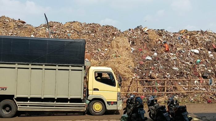 TRUK SAMPAH MELINRAS - Truk sampah melintas di Pasar Induk Kramat Jati, Jakarta Timur, Minggu (29/3/2026).  