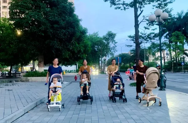 Người cao tuổi đẩy trẻ đi dạo tại một khu chung cư ở phường Đông Ngạc, Hà Nội tháng 6/2026. Ảnh: Phan Dương