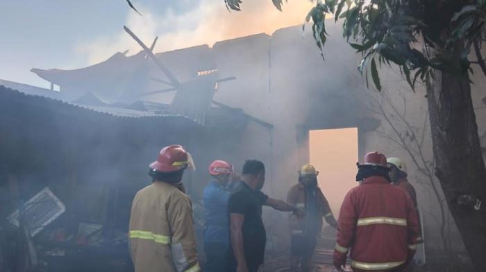 KEBAKARAN -- Petugas pemadam kebakaran berjibaku memadamkan api yang membakar sebuah gudang penyimpanan di Jalan Tengah, Kelurahan Limba B, Kecamatan Kota Selatan, Kota Gorontalo, Jumat (31/7/2026) sore. Kepulan asap tebal terlihat membumbung dari lokasi kebakaran saat petugas berupaya mencegah api merembet ke rumah warga.