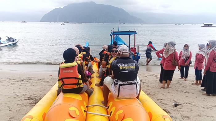 WISATAWAN - Pengunjung Pantai Mutiara Kabupaten Trenggalek Jawa TImur, sedang menikmati keindahan alam dengan hamparan pasir bersih, Sabtu (1/8/2026) Sabtu. Ombak yang tidak terlalu besar memungkinkan untuk bermain air, karena pantai ini berada di dalam Teluk Prigi.