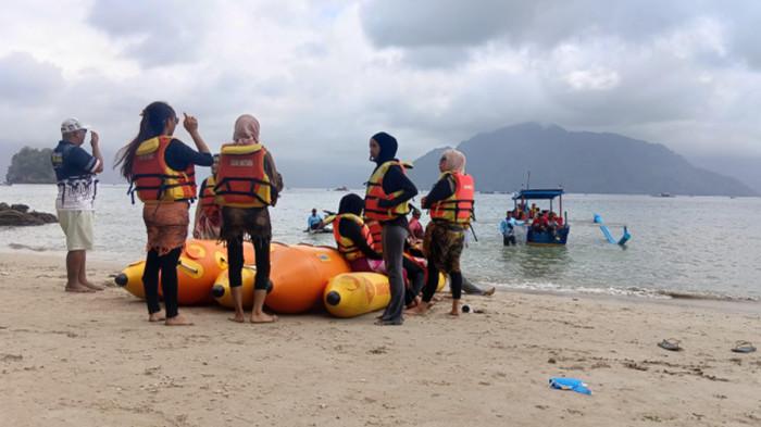 WISATAWAN - Pengunjung Pantai Mutiara Kabupaten Trenggalek Jawa TImur, sedang menikmati keindahan alam dengan hamparan pasir bersih, Sabtu (1/8/2026) Sabtu. Ombak yang tidak terlalu besar memungkinkan untuk bermain air, karena pantai ini berada di dalam Teluk Prigi.
