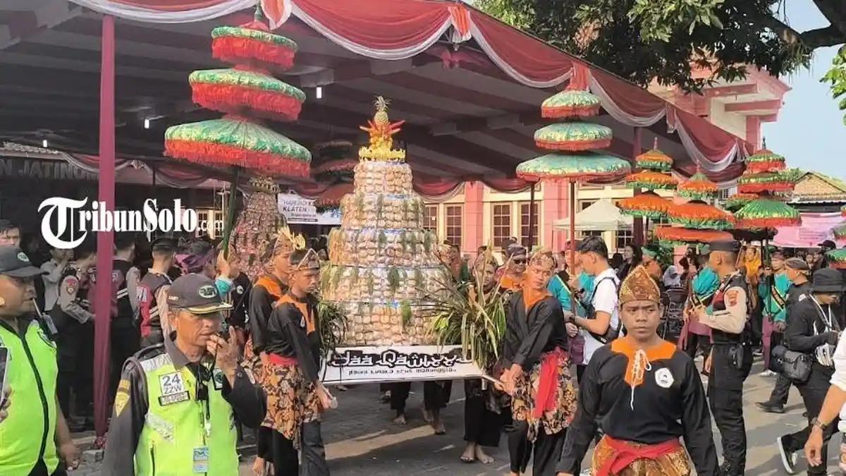 KIRAB GUNUNGAN APEM - Dua gunungan apem dilakukan kirab, menandai perayaan sebaran apem akan segera dilakukan di Desa dan Kecamatan Jatinom, Kabupaten Klaten, Kamis (7/8/2025).