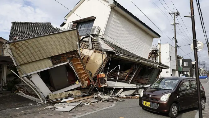 Sebuah kendaraan melintas di dekat rumah-rumah yang runtuh setelah gempa bumi di Yatsushiro, Prefektur Kumamoto, Rabu, 29 Juli 2026. (Juntaro Yokoyama/Kyodo News via AP)