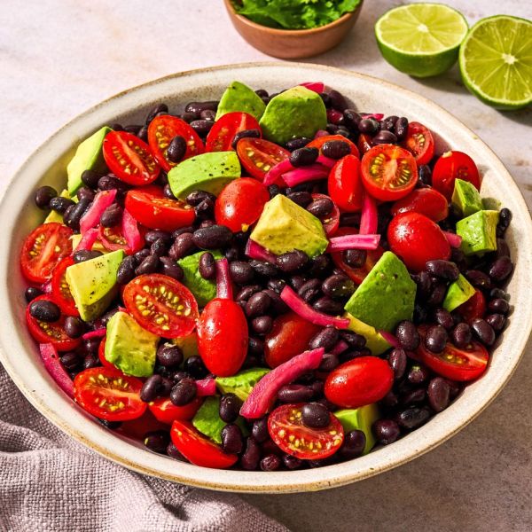 Bowl containing avocado black beans cherry tomatoes and red onions Credit: Ali Redmond