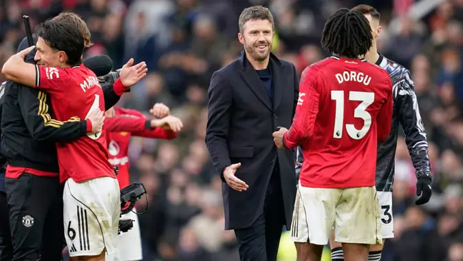 Michael Carrick Pelatih kepala Manchester United, Michael Carrick, di tengah, menyapa Patrick Dorgu dari Manchester United setelah pertandingan Liga Inggris antara Manchester United dan Manchester City di Manchester, Inggris, Sabtu, 17 Januari 2026. (AP Photo/Dave Thompson)