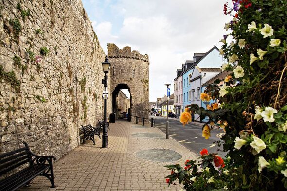 Tenby town wall along South Parade with seasonal flower decoration