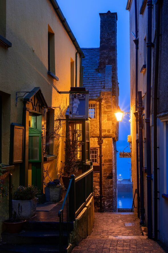 Tudor Merchant's House (with chimney), Quay Hill, Tenby, Pembrokeshire, Wales. Looking towards the harbour, early morning.