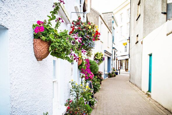 alleyway decorated with flower baskets in Tenby, UK