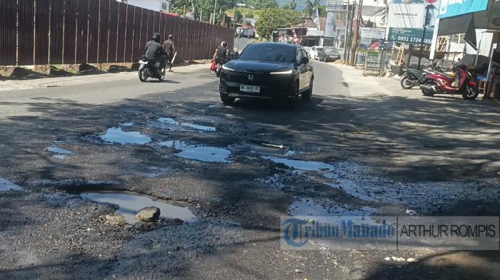 LUBANG - Deretan lubang mengintai di tengah jalan raya Manado - Tomohon di Kelurahan Winangun Atas, Kecamatan Pineleng, Kabupaten Minahasa, provinsi Sulawesi Utara (Sulut). Keberadaan lubang jalan tersebut dituding sebagai salah satu penyebab kemacetan parah di lokasi tersebut