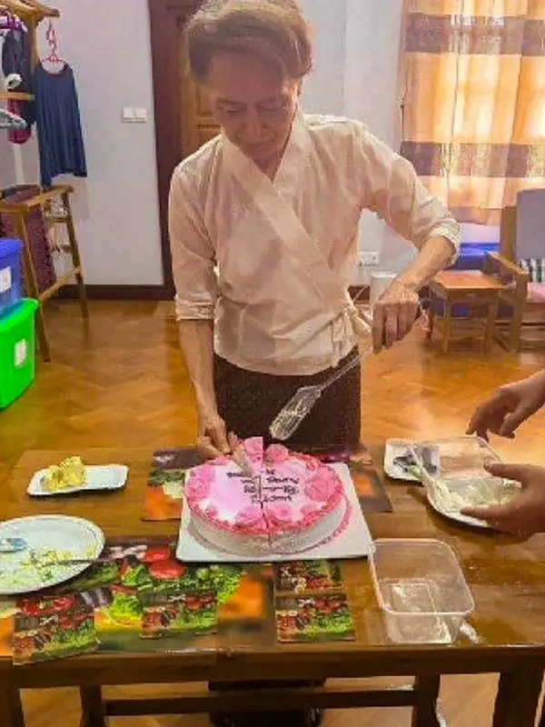 Mantan pemimpin sipil yang ditahan Aung San Suu Kyi memotong kue saat  bertemu dengan perwakilan tetap Komite Internasional Palang Merah (ICRC) untuk Myanmar Arnaude de Baecque di Naypyidaw, Myanmar, Senin, 3 Agustus 2026. (AFP/ Biro Pers dan Informasi Kepresidenan Myanmar )