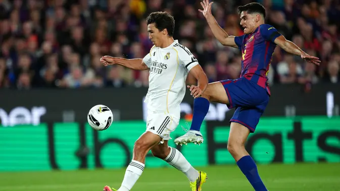Pemain Barcelona, Gerard Martín (kanan), berebut bola dengan pemain Real Madrid, Gonzalo Garcia, dalam pertandingan Liga Spanyol di Camp Nou, Spanyol, Senin (11/5/2026) dini hari WIB. (AP Photo/Joan Mateu Parra)