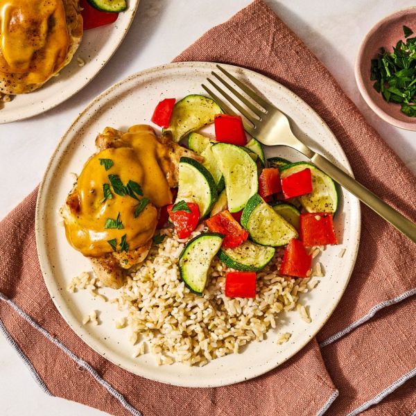 Plate of honey mustard chicken zucchini red peppers and rice with a fork placed on a napkin Credit: Ali Redmond