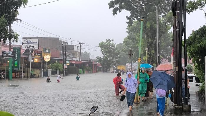 BANJIR MENGGENANGI JALAN- Penampakan banjir di Simpang Empat Lampu Merah Alai, Kecamatan Padang Utara, Kota Padang, Senin (3/8/2026) sore. Banyak kendaraan yang mogok, beberapa masyarakat ikut membantu mendorong.