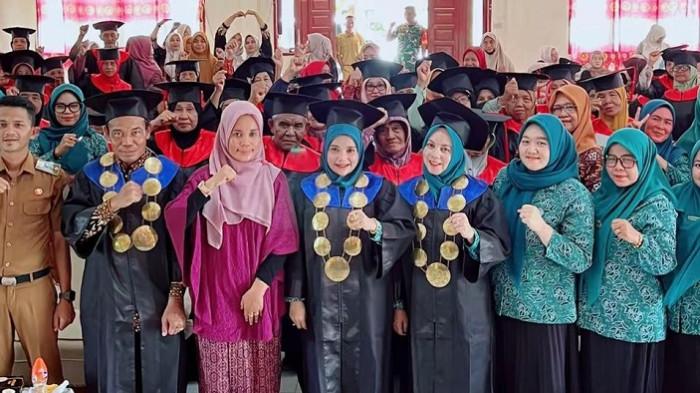 Ketua TP PKK Kabupaten Aceh Timur, Ny. Dr. Lismawani Iskandar Al-Farlaky, S.Pd., M.Ag., saat memindahkan toga wisuda lansia di Aula Kantor Camat Bireum Bayeun, Selasa (4/8/2026).