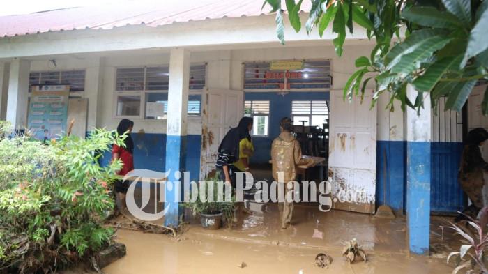 PEMBERSIHAN SISA BANJIR- Suasana aksi gotong royong darurat saat jajaran pendidik dan murid membersihkan lumpur pekat sisa banjir di SMPN 41 Padang, Kuranji, Kota Padang, Selasa (4/8/2026).