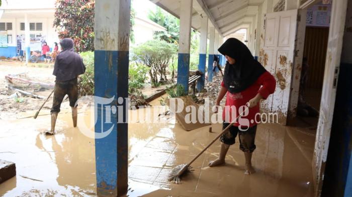 BANJIR- Para siswa SMPN 41 Padang menggelar goro bersama membersihkan sedimen lumpur yang terbawa banjir hingga memenuhi ruangan kelas, Selasa (4/8/2026).
