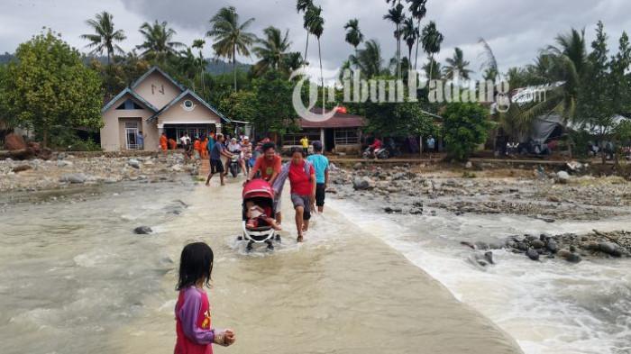 BANJIR LAPAU MUNGGU - Sejumlah warga melintasi genangan air di kawasan Lapau Munggu, RT 02/RW 06, Kelurahan Kuranji, Kota Padang, Selasa (4/8/2026). Wali Kota Padang Fadly Amran menilai banjir yang melanda sejumlah wilayah di Kota Padang tidak hanya dipengaruhi tingginya curah hujan, tetapi juga derasnya aliran air yang datang dari kawasan hulu sehingga tidak lagi mampu terbendung.