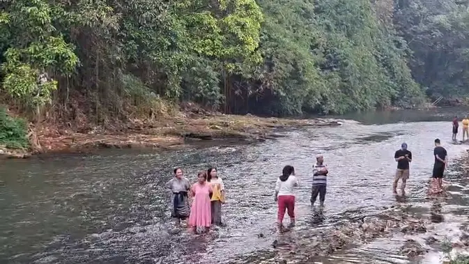 Sejumlah warga dan tim evakuasi gabungan berusaha melakukan pencarian anak tenggelam di aliran Sungai Ciliwung, Depok. (Liputan6.com/Dicky Agung Prihanto)