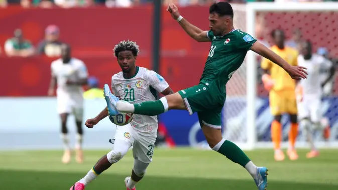 Penyerang Senegal bernomor punggung 20, Ibrahim Mbaye, dan bek Irak bernomor punggung 26, Frans Putros, berebut bola selama pertandingan Grup I Piala Dunia 2026 antara Senegal dan Irak di Stadion Toronto, Toronto, pada 27 Juni 2026. (Cole Burston/AFP)