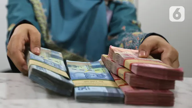 Teller menunjukkan mata uang rupiah di bank, Jakarta. (Liputan6.com/Angga Yuniar)