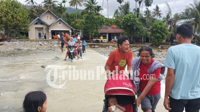BANJIR LAPAU MUNGGU- Sejumlah warga melintasi genangan air di kawasan Lapau Munggu, RT 02/RW 06, Kelurahan Kuranji, Kota Padang, Selasa (4/8/2026).