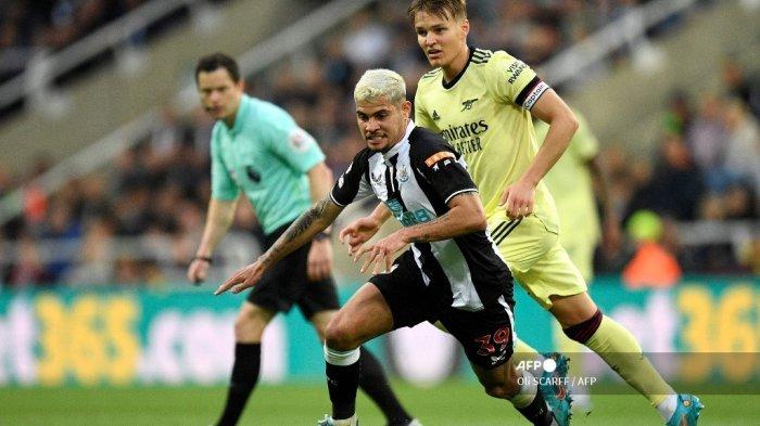 Gelandang Arsenal asal Norwegia Martin Odegaard (kanan) bersaing dengan gelandang Newcastle United Brasil Bruno Guimaraes selama pertandingan sepak bola Liga Premier Inggris antara Newcastle United dan Arsenal di St James' Park di Newcastle-upon-Tyne, Inggris timur laut pada 16 Mei 2022.
