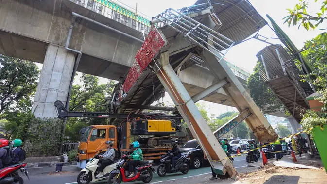 Sebuah truk  truk towing pengangkut alat berat (crane)  tersangkut dan merusak  jembatan penyeberangan orang (JPO) di Jalan Raya Kapten Tendean, Jakarta, Selasa (14/07/2026).