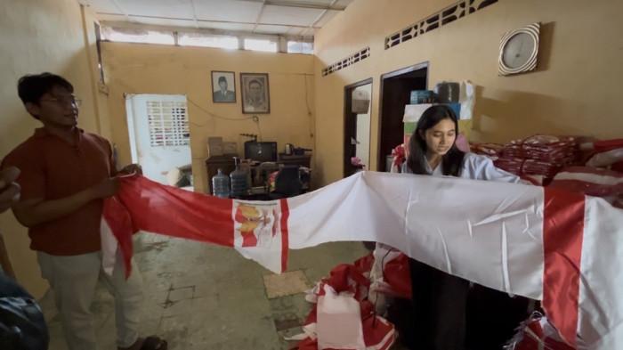 MENATA BENDERA - Pasangan suami istri Generasi Z, Fahmi Babgae (28) dan Regita Sekar Adisti (28), menata sekaligus menunjukkan bendera Merah Putih, umbul-umbul, bandir, dan berbagai ornamen peringatan HUT ke-81 RI di rumah mereka di Jalan Purwodinatan, Kecamatan Semarang Tengah, Kota Semarang, Selasa (4/8/2026). Usaha yang mereka rintis sejak 2016 itu kini kebanjiran pesanan dari RT/RW, perkantoran, pusat perbelanjaan, hingga instansi pemerintah menjelang peringatan Hari Kemerdekaan.