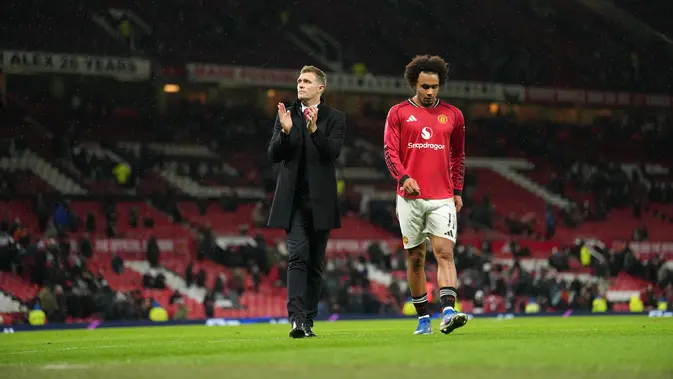 Manajer interim Manchester United Darren Fletcher berjalan meninggalkan lapangan bersama pemain Manchester United Joshua Zirkzee usai laga putaran ketiga FA Cup/Piala FA antara Manchester United vs Brighton di Manchester, Inggris, Minggu, 11 Januari 2026. (AP Photo/Jon Super)