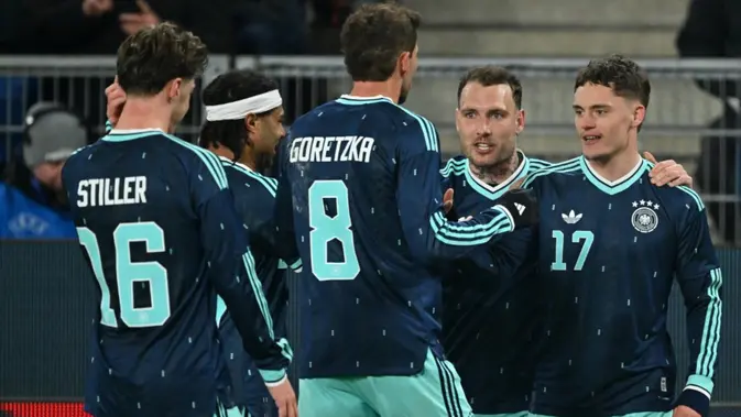 Gelandang Jerman #17, Florian Wirtz, merayakan gol ketiga timnya bersama rekan-rekan setimnya selama pertandingan persahabatan internasional antara Swiss dan Jerman di St. Jakob-Park di Basel, Swiss pada 28 Maret 2026. (Fabrice COFFRINI/AFP)