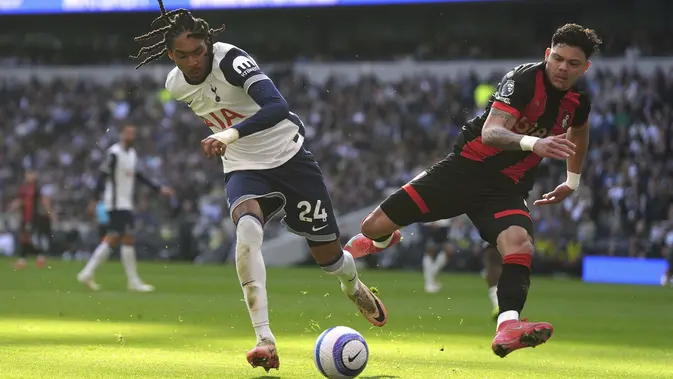 Pemain Tottenham Hotspur, Djed Spence, berebut bola dengan striker Bournemouth, Evanilson, dalam laga pekan ke-28 Premier League 2024/2025 di Tottenham Hotspur Stadium, Minggu (9/3/2025) malam WIB. Tottenham dan Bournemouth berbagi poin setelah pertandingan berakhir imbang 2-2. (Bradley Collyer/PA via AP)
