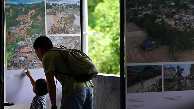 Pengunjung melihat karya pameran foto jurnalistik Prahara Pulau Emas di Museum Tsunami Aceh, Banda Aceh, Aceh, Sabtu, 8 Agustus 2026. (AFP/ Chaideer Mahyuddin)